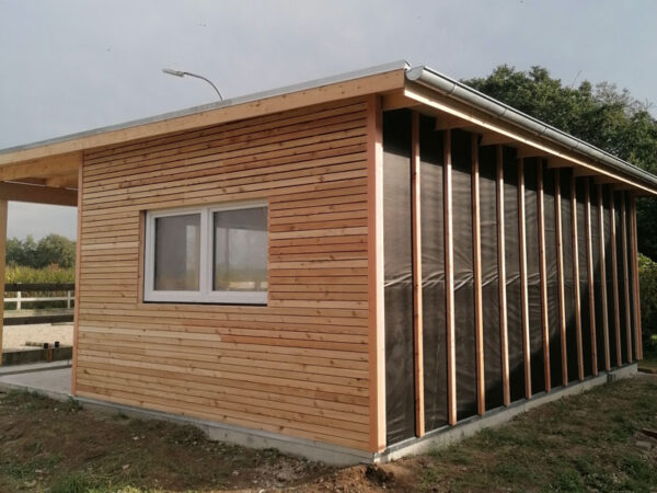 Gartenhaus mit Holzverkleidung und überdachter Terrasse